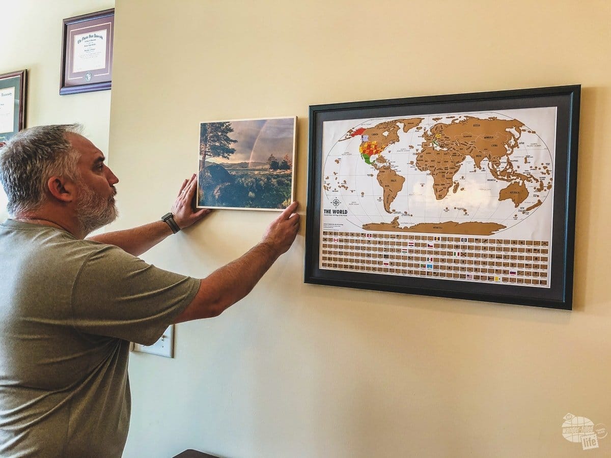 So, we got the Landmass Goods Travel Tracker Scratch Off map hung and now we are hanging one picture from every trip surrounding the map. A scratch-off map is one of the most unique holiday gifts you could give.