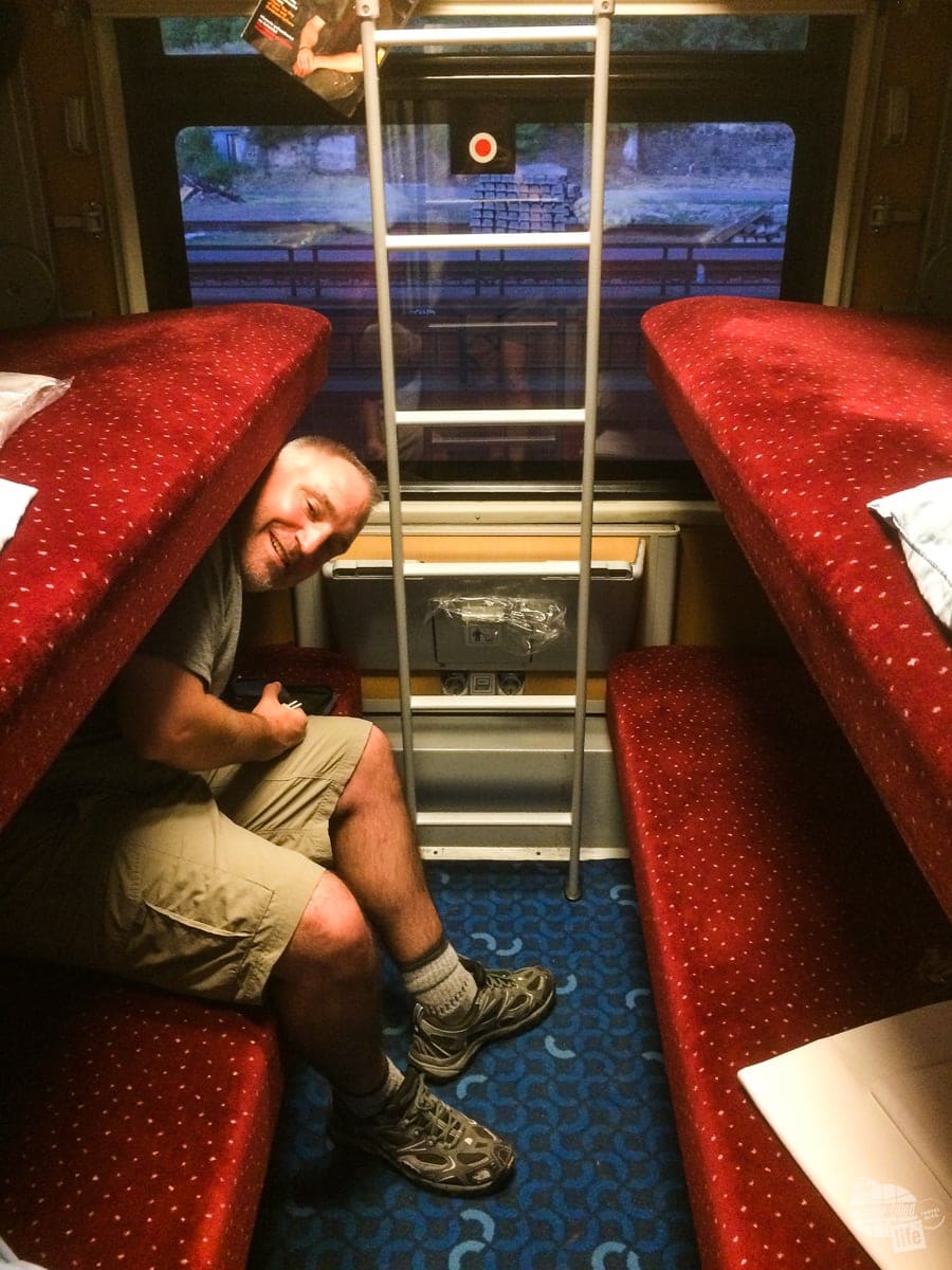 Grant getting into the bunk of the sleeper car. 