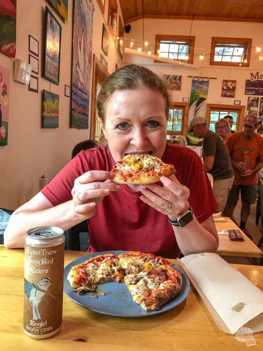 Bonnie taking a big bite of pizza at the Rivers Eatery in Cable, WI.