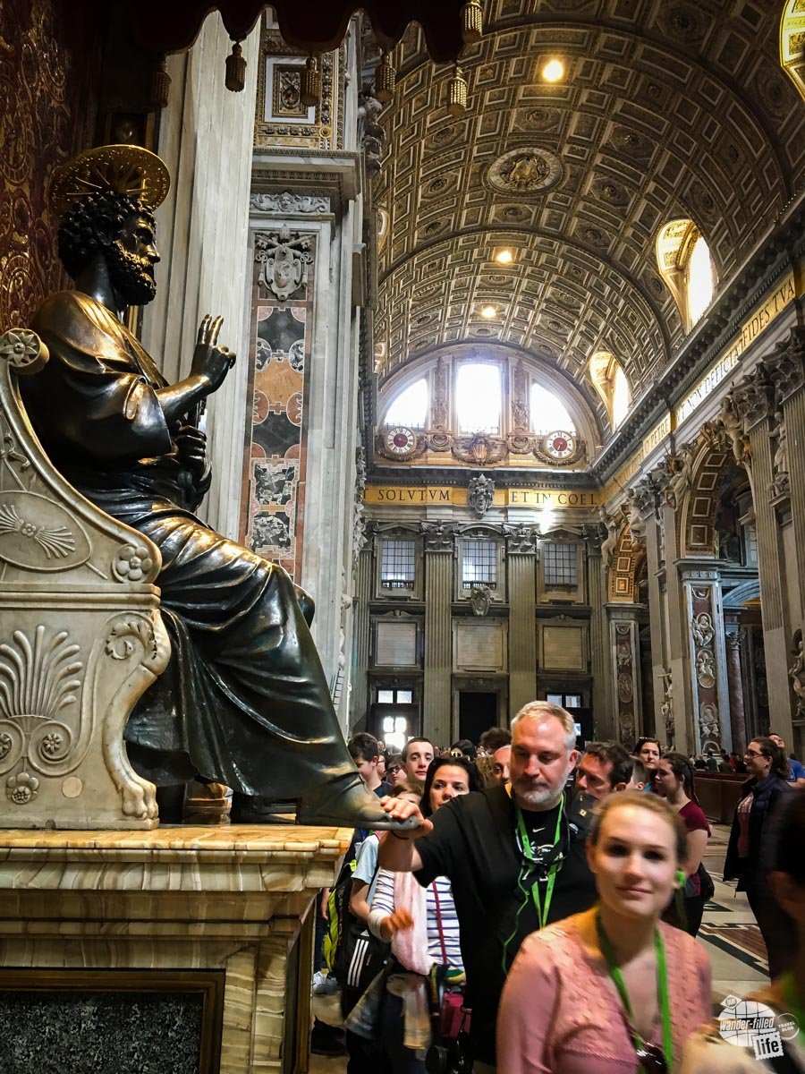 Grant rubbing the feet of St. Peter's statue in St. Peter's Basilica.