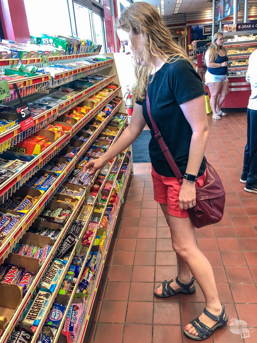 Bonnie grabbing a Snickers at the gas station - good snacks are a road trip essential.