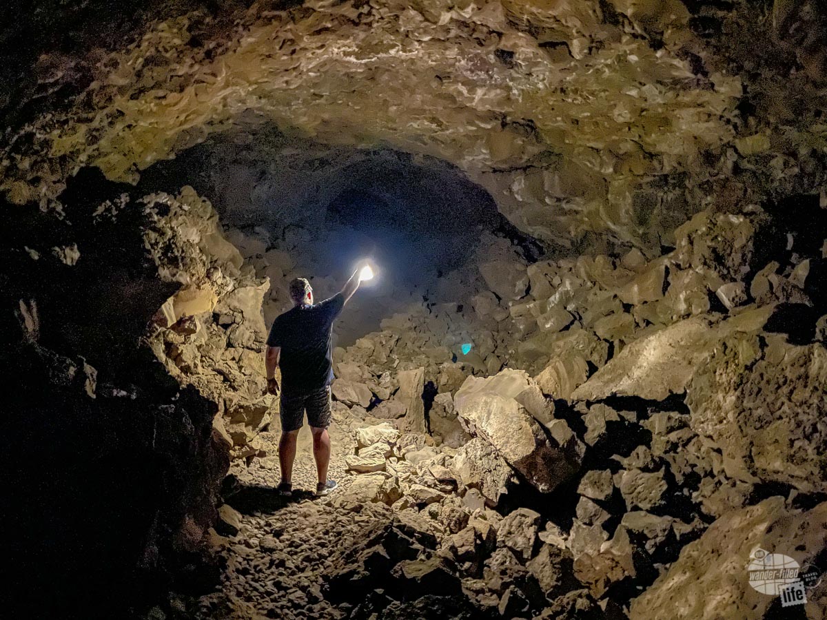 Grant holding a lantern inside a cave.